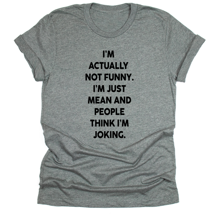 Deep Heather unisex t-shirt with bold white text that reads: ‘I’m actually not funny. I’m just mean and people think I’m joking.’ Shirt laid flat with rolled sleeves.”