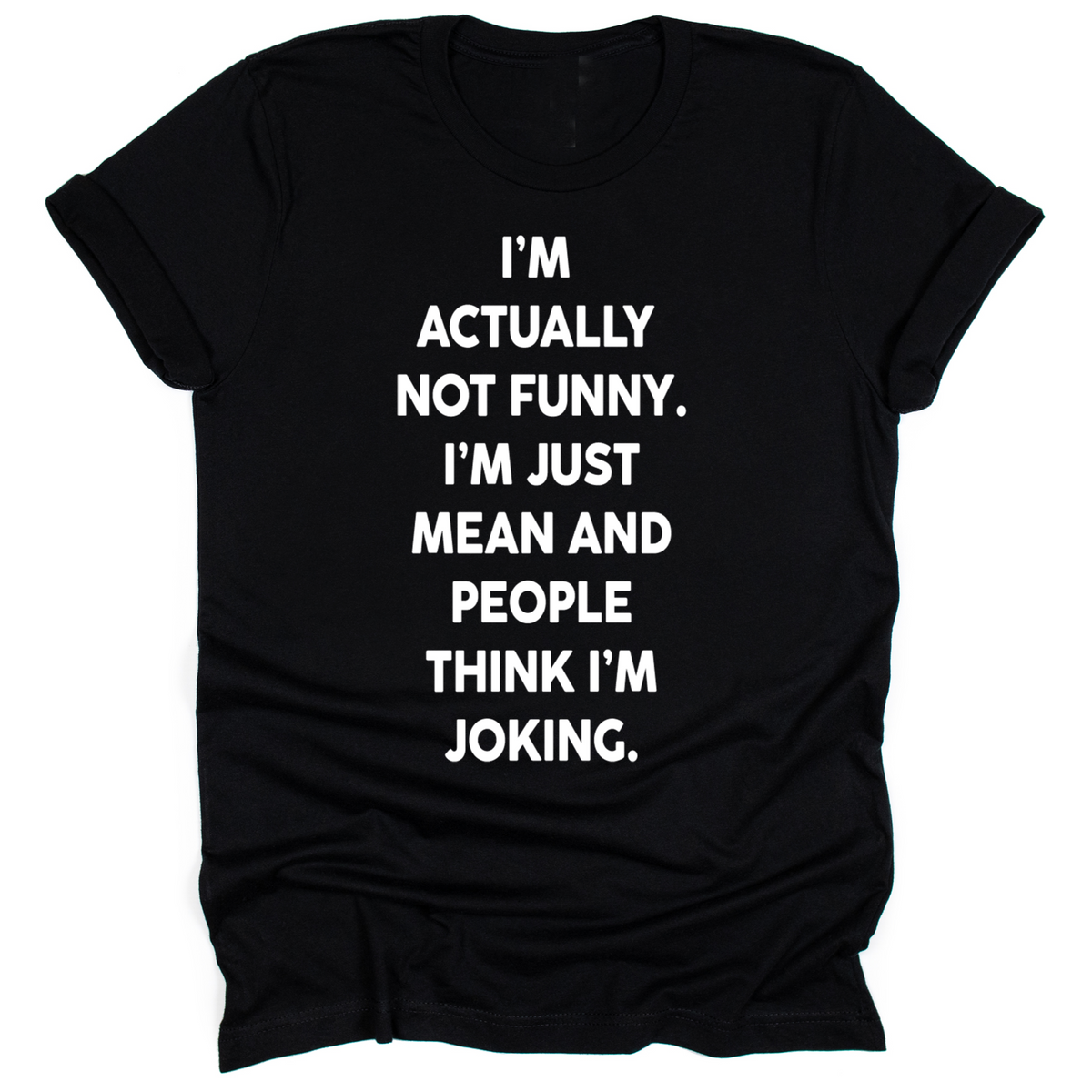 Black unisex t-shirt with bold white text that reads: ‘I’m actually not funny. I’m just mean and people think I’m joking.’ Shirt laid flat with rolled sleeves.